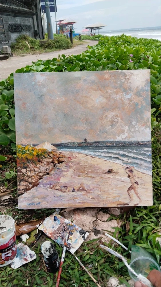 Painting the Spirit of Bali Beneath the Seminyak Sun - Arts of Bali A completed masterpiece painting sitting on the beach sand surrounded by paint bottles and artistic tools after the wave incident