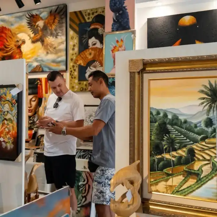 Customer and artist at Arts of Bali gallery discussing a new custom painting Bali for their home decor