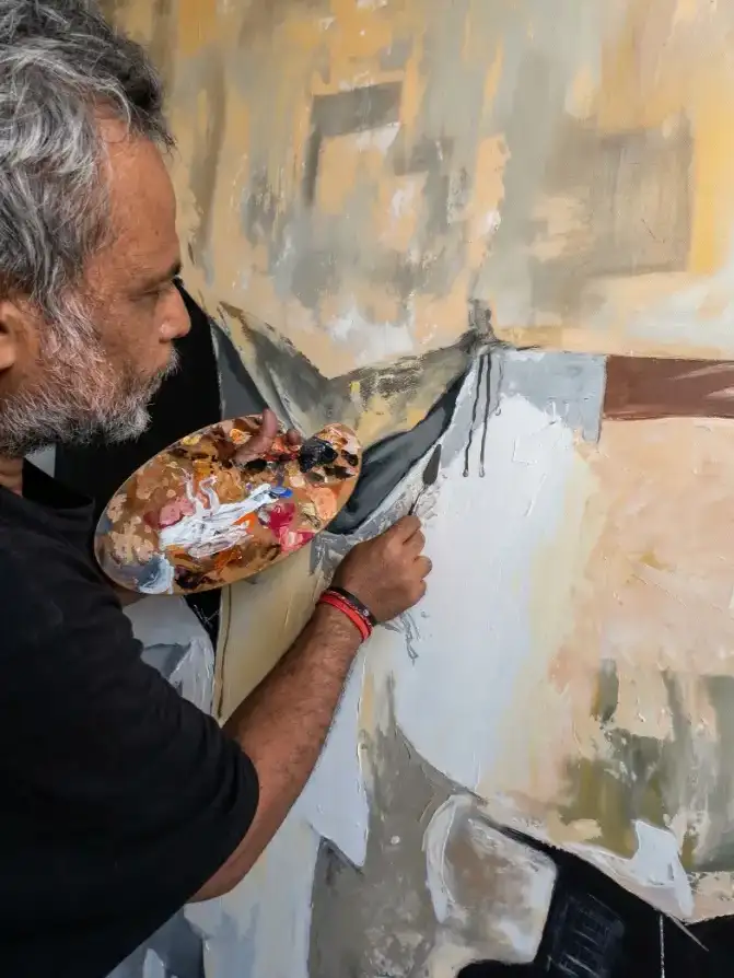 Professional Balinese artist using a palette knife to create a handmade custom painting Bali at Arts of Bali studio