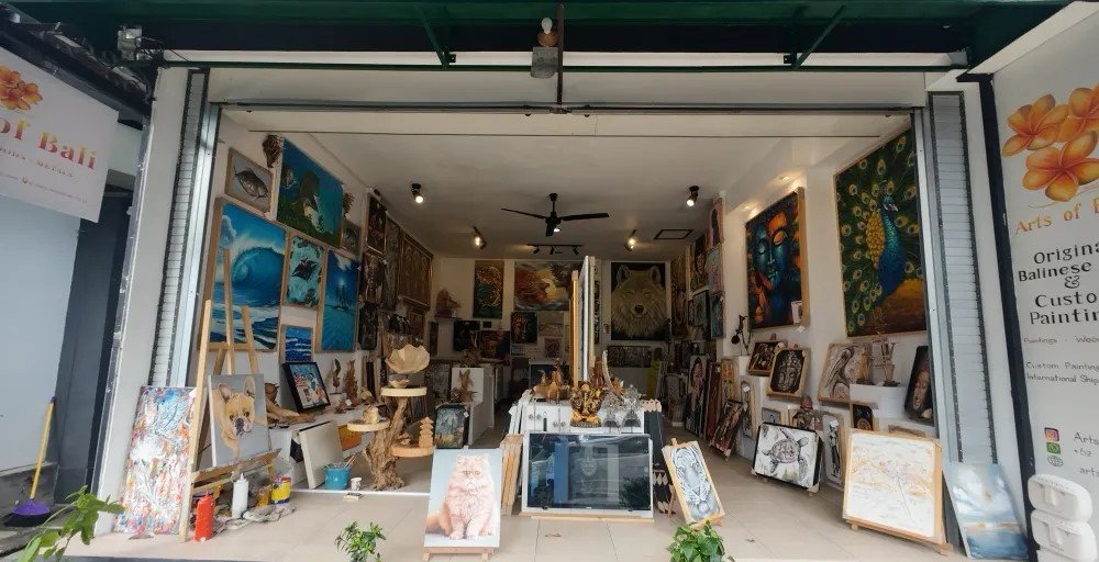 Interior view of Arts of Bali gallery and studio at night showing a rich collection of original Balinese and Indonesian paintings on display