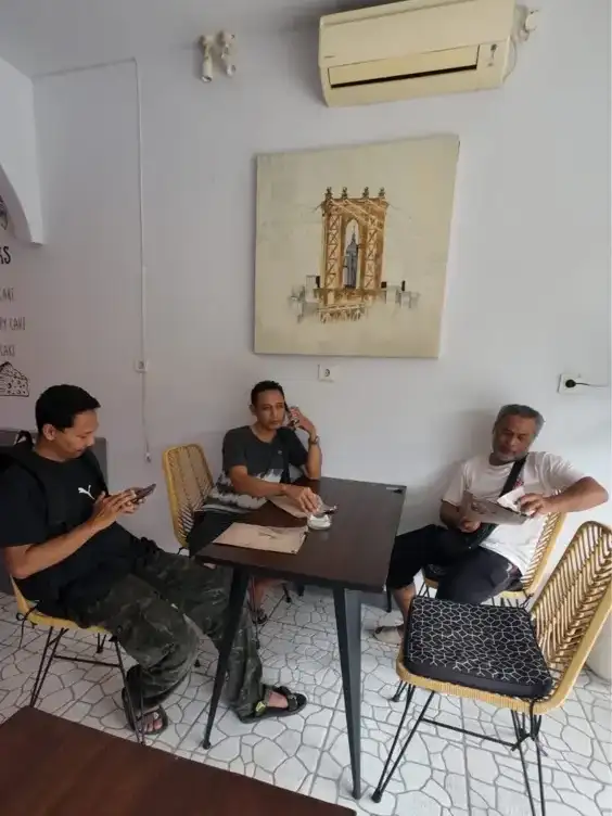 Arts of Bali team members reviewing and researching original Balinese paintings during creative development session in Seminyak