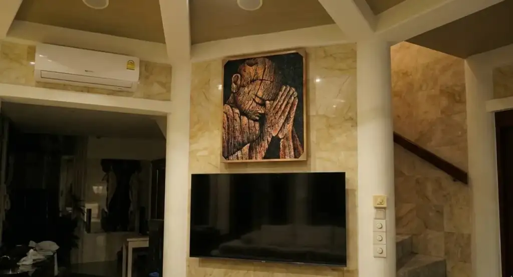 Commissioned Textured Realism Paintings in Bali - Arts of Bali Final installation of a large-scale Buddha masterpiece from the Commissioned Textured Realism Paintings Bali collection, perfectly mounted on a marble wall above the TV in a luxury living room sanctuary.