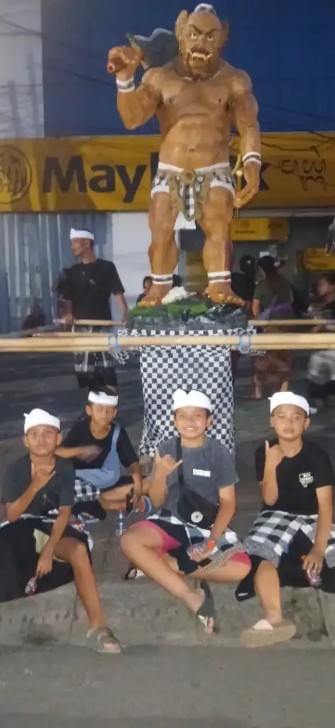 From the Noise to the Silence: Nyepi with the Arts of Bali Family - Arts of Bali Four young boys in traditional Balinese dress posing in front of their ogoh-ogoh demon statue during pengerupukan celebrations in Bali