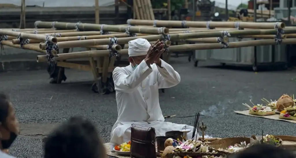 From the Noise to the Silence: Nyepi with the Arts of Bali Family - Arts of Bali Balinese pemangku priest dressed in white sitting cross-legged in prayer with ceremonial offerings and incense during an afternoon ritual blessing before Nyepi