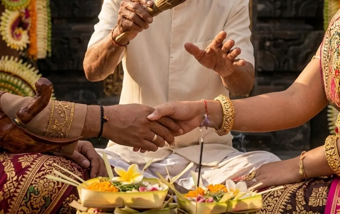 Close-up of a Balinese wedding ritual showing holy water blessing and traditional gold jewelry