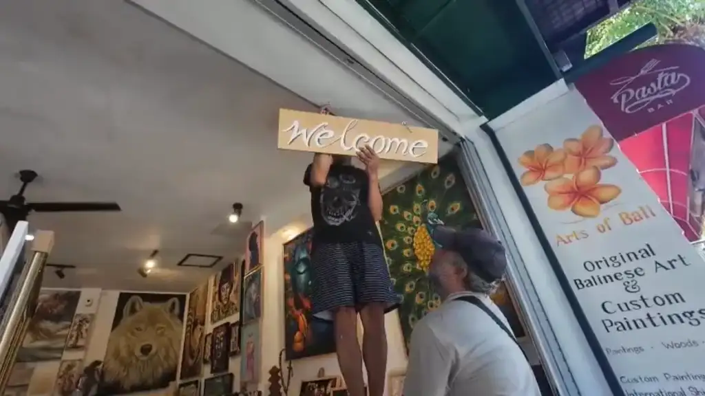 Welcome sign being hung at entrance of Arts of Bali Balinese art gallery