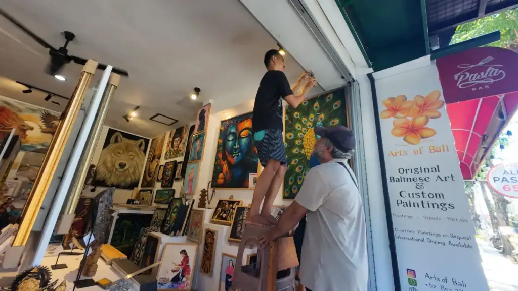 Local artisans installing a handmade wooden sign at our gallery entrance