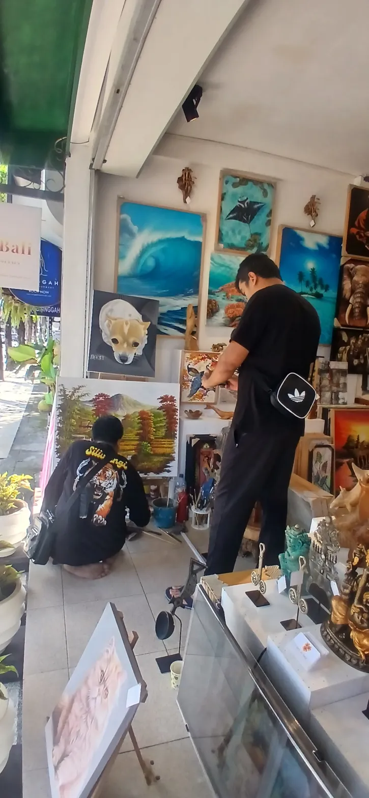 Visitors browsing original Balinese paintings before deciding to ship painting from Bali