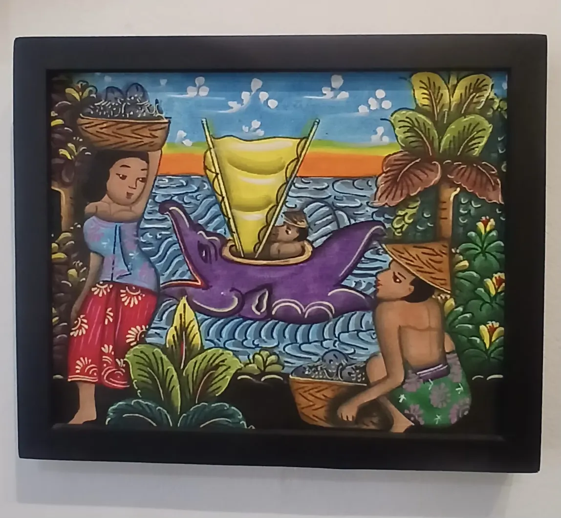Small framed Batuan painting Bali showing a coastal scene with a Balinese woman carrying a basket, a fisherman, and a purple manta ray in a stylised sea with a sailing jukung
