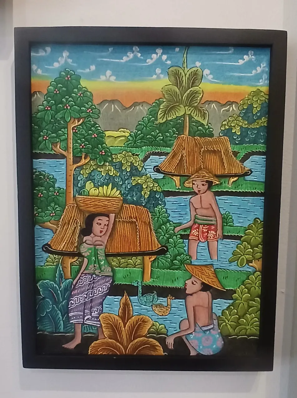Batuan painting Bali showing Balinese rice field harvest scene with farmers in woven hats carrying baskets through green terraces with mountains in the background