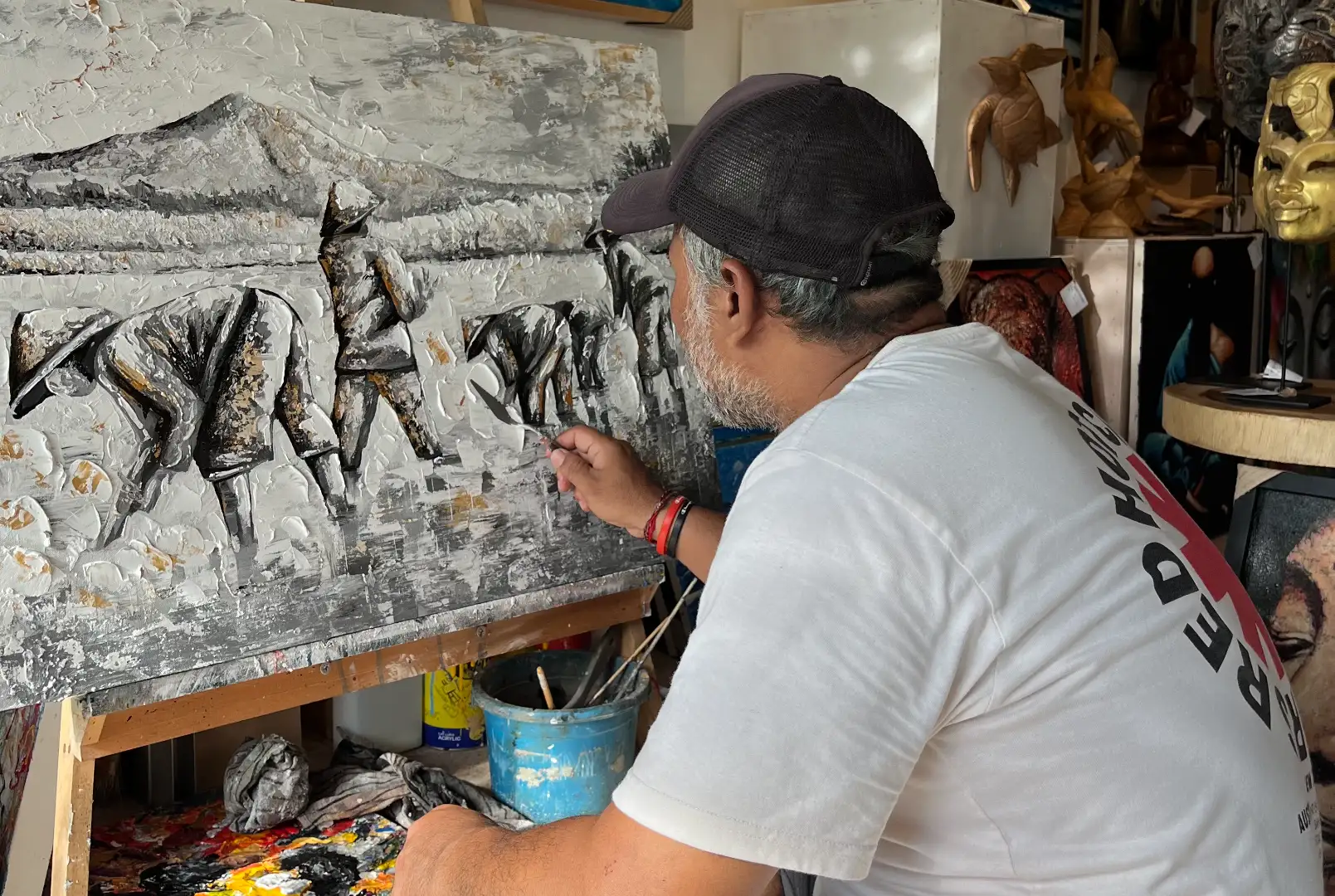 Palette Knife Artist Upeksa at Work — Rice Worker Canvas in Studio, Arts of Bali Palette knife artist Upeksa at his easel working on a large monochrome impasto canvas of rice workers in the Arts of Bali studio in Seminyak