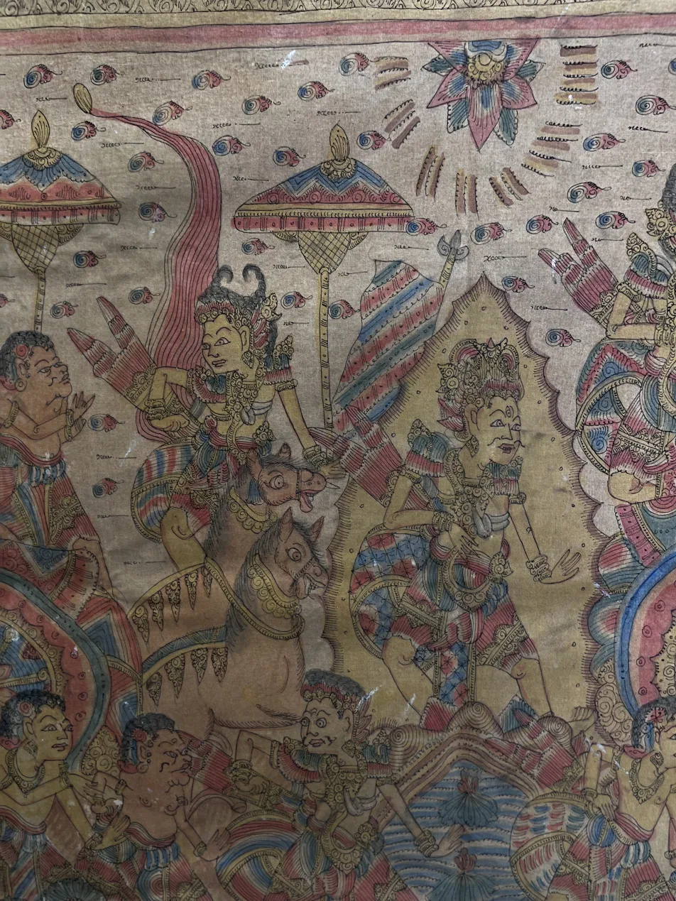 Balinese mythology painting close-up — Kamasan classical detail showing warrior king on horseback with Kawi script text, intricate costume detail and traditional Balinese iconographic precision