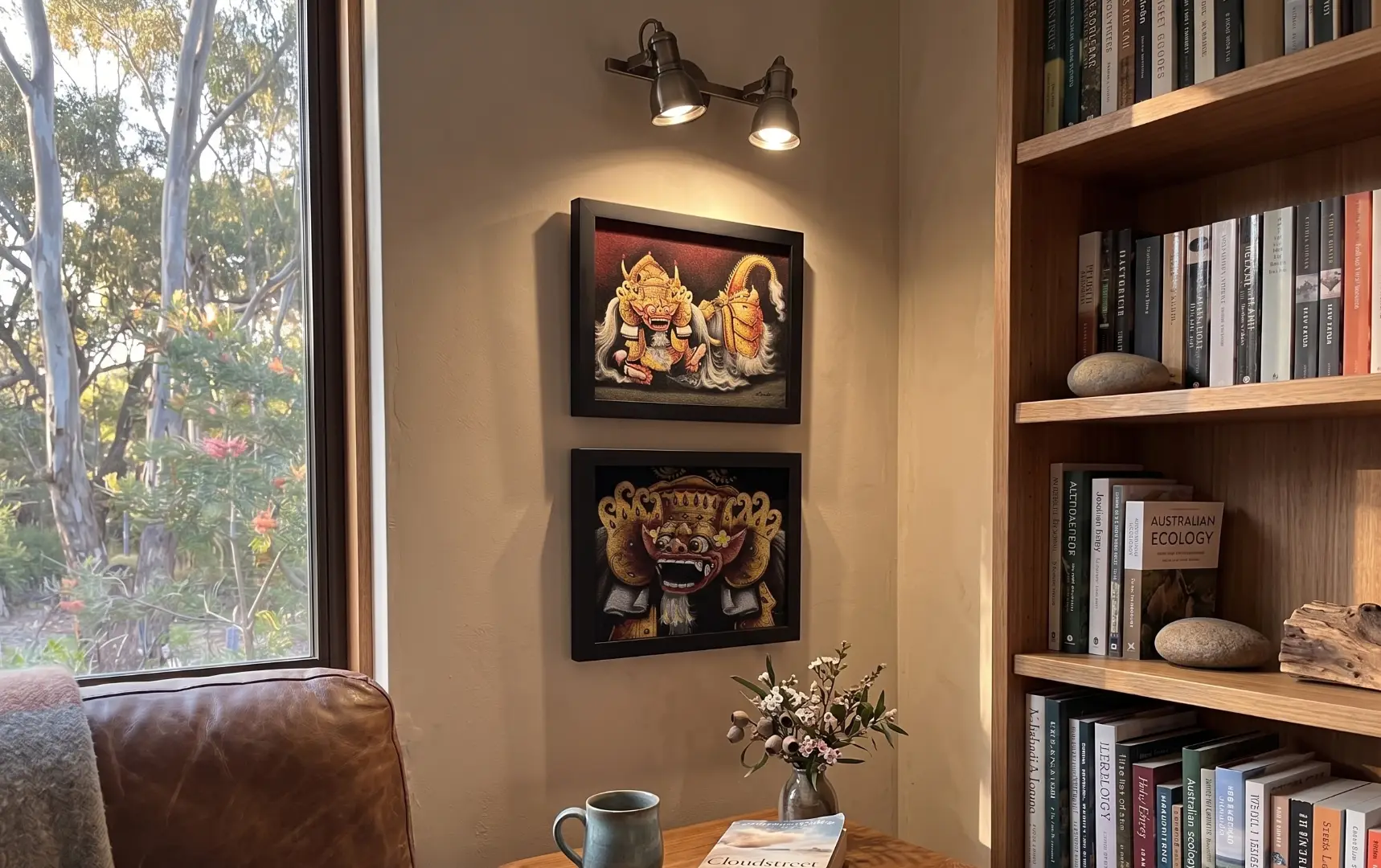 How to Choose Art in Bali — Barong Portraits Gallery Wall, Reading Nook, Vertical Arrangement How to choose art in Bali — two Barong portrait paintings by Kadek stacked vertically as a gallery wall in a cozy reading nook with bookshelf Australian home