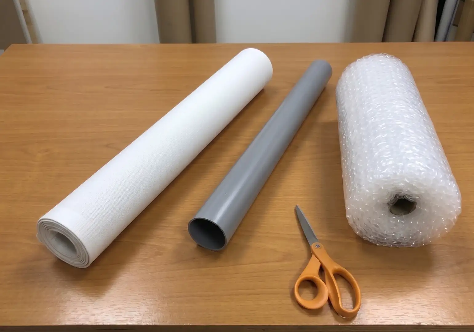 Professional art packing method showing a rolled canvas and a rigid PVC tube used to store and protect paintings from humidity