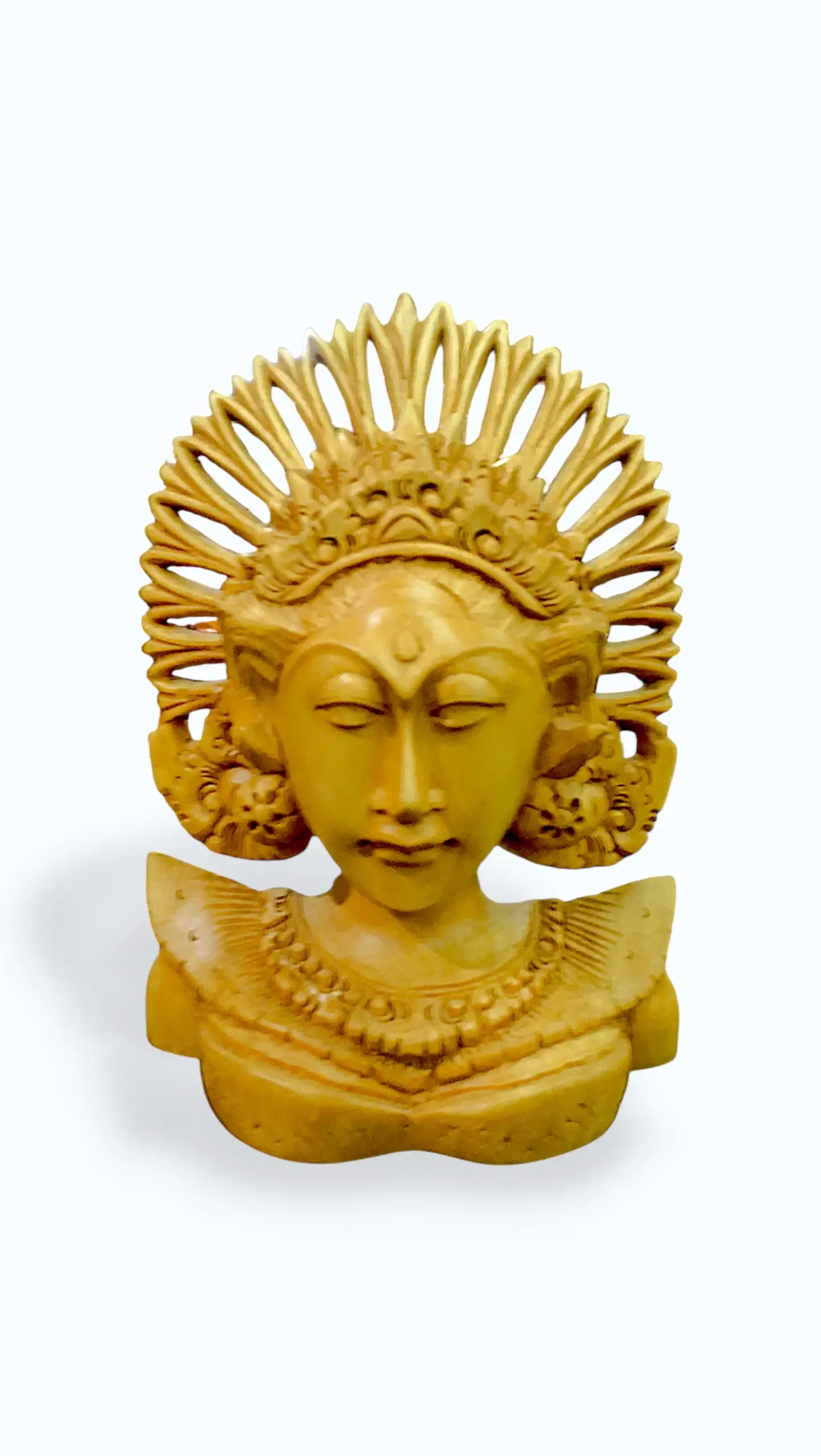 Balinese wood carving bust of Janger dancer with tall radiating sun-ray crown headdress, serene closed eyes, flower ear ornaments, and detailed necklace in warm golden amber wood, Arts of Bali gallery Seminyak