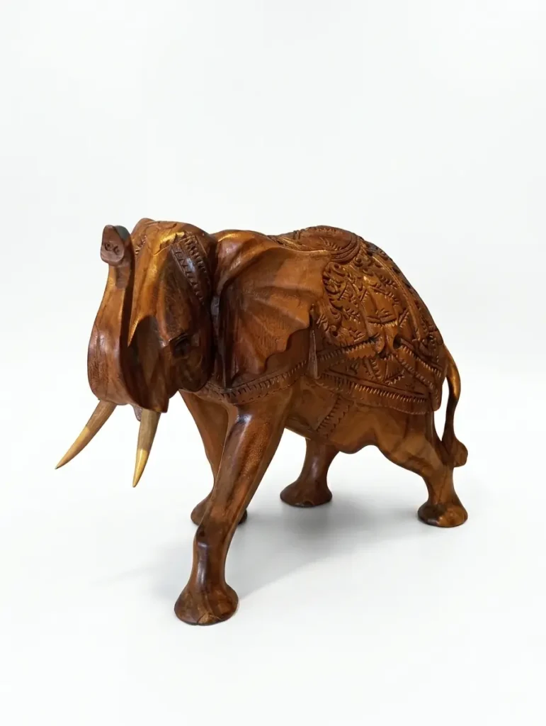 Detailed hand-carved ornate elephant wooden sculpture with intricate patterns, authentic Indonesian wood art from Arts of Bali.