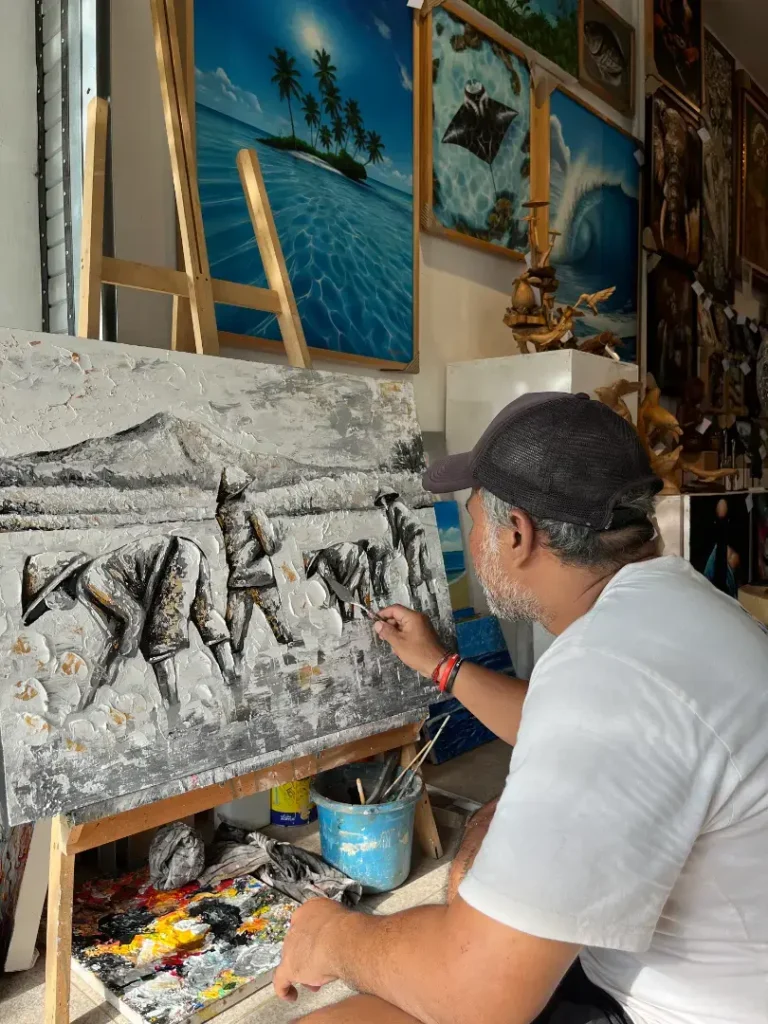 Balinese artist Upeksa working a palette knife painting in the Arts of Bali studio, Seminyak