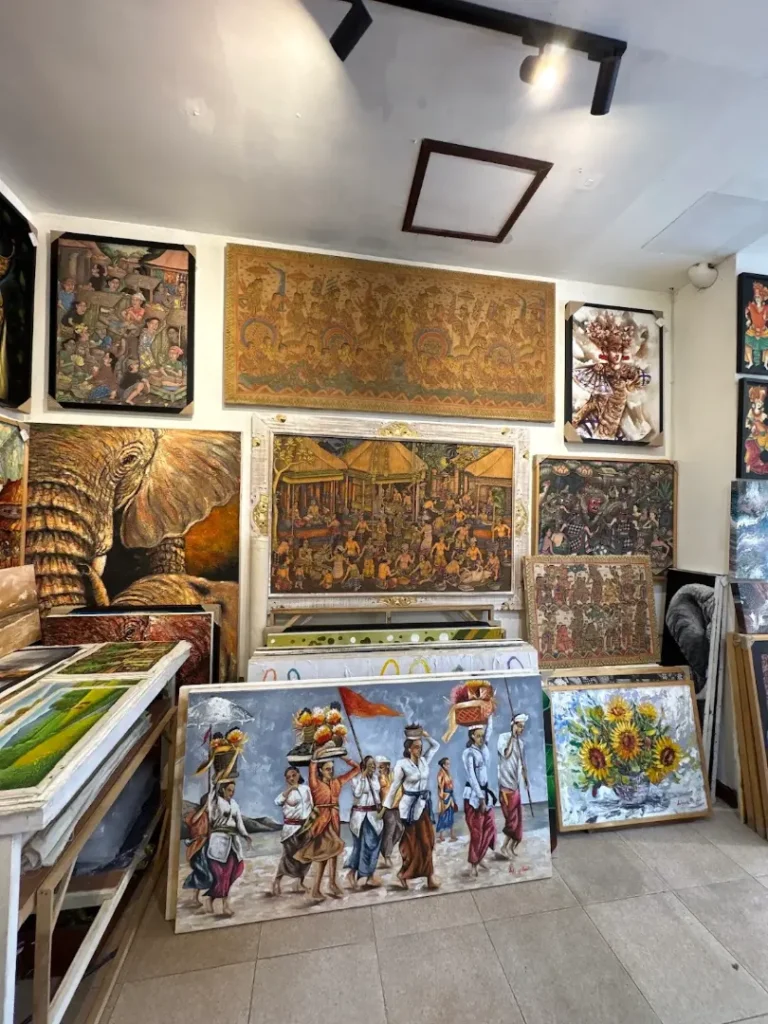 Wall of original Balinese paintings in multiple styles displayed together, Arts of Bali gallery, Seminyak