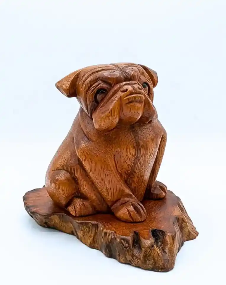 Hand-carved seated wrinkled pug bulldog figurine on natural wood slab from Arts of Bali.