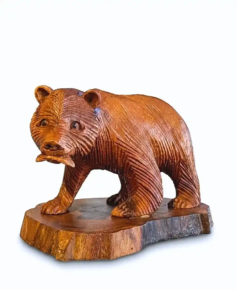 Hand-carved wooden grizzly bear catching a salmon on natural bark base from Arts of Bali.