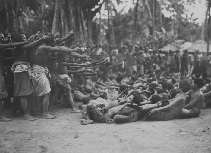 Historic 1935 photograph of a kecak dance in Bali with seated chorus and dancers